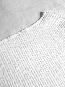 Macro view of white pleated fabric detail for elegant vacation style top