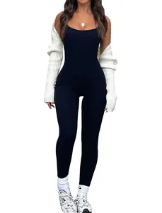Close-up view of a chic black sleeveless jumpsuit paired with a white ribbed shrug