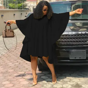 Mannequin portant une robe noire plissée grande taille à manches chauve-souris en plein air