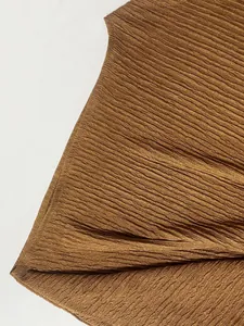 Macro di dettaglio del tessuto plissettato marrone per un elegante set da vacanza
