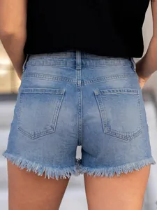 Detalle trasero de shorts vaqueros desgastados para mujer con dobladillo deshilachado