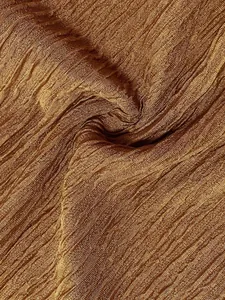 Primo piano del tessuto plissettato bronzo dorato con eleganti dettagli materici