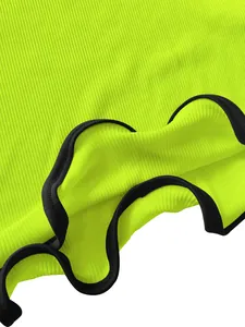 Macro detail shot showing neon green ribbed fabric and black wavy lettuce edge trim finish
