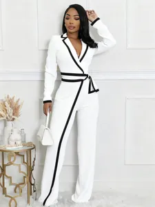 Elegante mono blanco de manga larga con ribetes negros en contraste y diseño de cinturón.