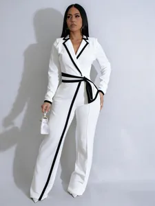 Elegante mono blanco de manga larga con ribete negro en contraste y cinturón de lazo