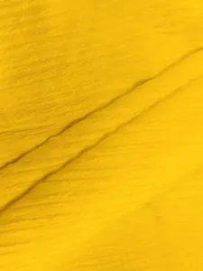 Dettaglio macro della trama del tessuto giallo brillante traspirante per abbigliamento estivo
