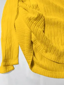 Vista dettagliata della trama del tessuto stropicciato giallo e dell'orlo di un top estivo