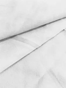 Vue macro détaillée d'un tissu plissé blanc doux montrant les détails du tissage fin
