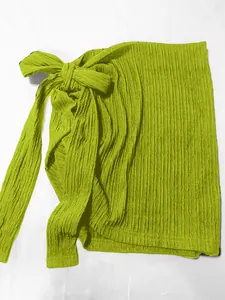 Dettaglio di una gonna a portafoglio verde lime con texture increspata e fiocco per vacanze