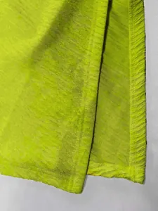 Dettaglio macro del tessuto increspato verde lime strutturato di questo set da spiaggia