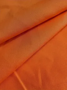 Gros plan macro montrant la texture du tissu tissé orange vif pour détails de vêtement