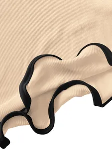 Detailed view of beige rib-knit fabric featuring a black contrast lettuce hem design.
