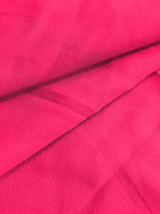 Vue macro montrant la texture détaillée du tissu plissé rose vif de la robe ample
