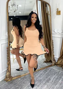 Full length mirror reflection of a sleeveless apricot ribbed dress with black wavy hem