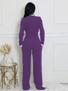 Vista trasera de un mono morado de manga larga con elegante cuello y puños en contraste blanco