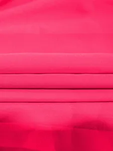 Détail en gros plan d'un tissu plissé rose fuchsia avec une texture et des plis fins