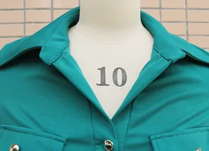 Close-up view of the classic collar and silver metal button detail on a teal jumpsuit.