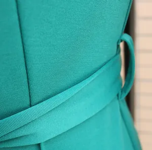 Detailed close-up showing the waist belt and fine fabric texture of this green jumpsuit.