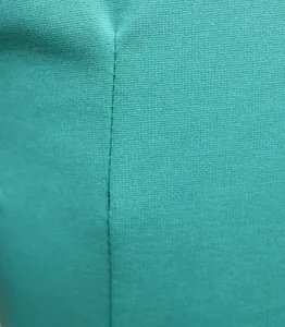 Detailed macro view of the high-quality teal fabric and durable seam on this jumpsuit