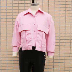 Detail of a stylish pink batwing sleeve shirt featuring oversized flap pockets