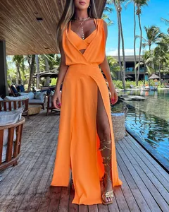 Detailed view of vibrant orange two-piece resort outfit featuring high-slit maxi skirt