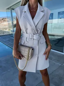 Close-up of elegant cream sleeveless blazer dress showing belt and button details