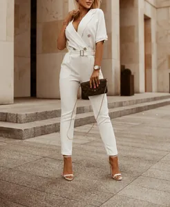 Moderner weißer Jumpsuit mit Reverskragen in einer schicken städtischen Außenanlage.