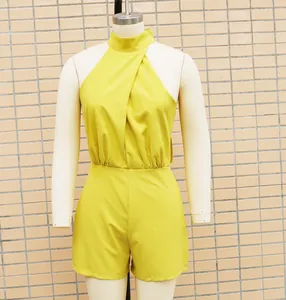Detailed macro view of a vibrant yellow sleeveless halter-neck jumpsuit shorts on a mannequin