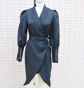 Detailed view of black shawl collar wrap dress with puff sleeves and buttoned cuffs