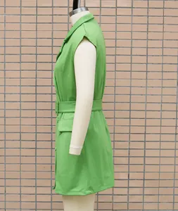 Side view detail of a lime green sleeveless blazer dress with a matching waist belt.