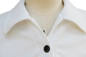 Dettaglio ravvicinato dell'elegante colletto bianco e del bottone nero sul vestito