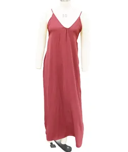 Detalle de un vestido largo suelto rojo ladrillo con tirantes finos en un maniquí blanco