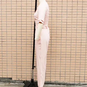 Seitenprofil-Detail eines rosafarbenen kurzärmeligen slim-fit Overalls mit Gürtel