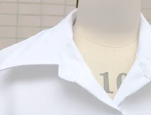 Close-up detail of a white women's collared office shirt on a professional mannequin