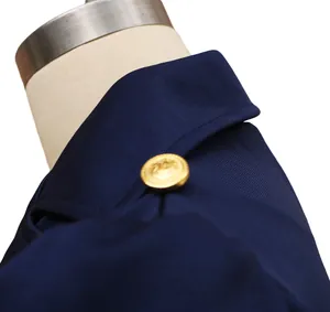 Detailaufnahme des dunkelblauen Kleiderkragens mit goldenem Knopf im Vintage-Stil