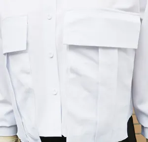 Close-up view showing fabric texture and large utility pockets of a white shirt.