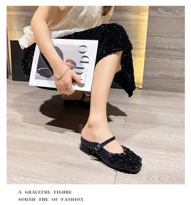Detailed view of black rhinestone Mary Jane block heel mules worn by model