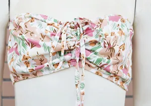 Primo piano di un elegante top a fascia con stampa floreale e arricciatura frontale