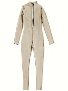Detailed view of a beige ribbed long-sleeved athletic jumpsuit with a black front zipper