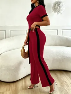Close-up of red ribbed two-piece set featuring cutout waist and side stripe wide-leg pants