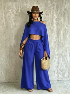 Vista de cuerpo entero de un conjunto azul de top corto sin hombros y pantalón ancho
