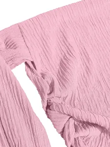 Macro shot showing the texture of pink crinkled fabric and elegant knot design detail.