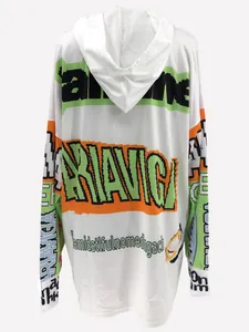 Detailed view of the oversized white hoodie with pixelated green and orange letter print.