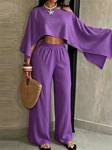 Detalle del conjunto de dos piezas violeta con top de hombros caídos y pantalón ancho