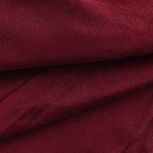 Close-up detail of high-quality wine red ribbed fabric texture on elegant bodycon dress