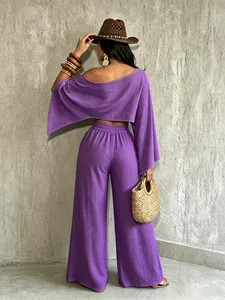 Vista trasera de un conjunto de vacaciones violeta con top sin hombros y pantalón ancho.