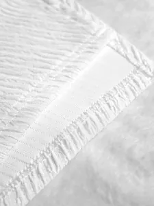 Close-up macro detail showing white textured fabric and professional stitching on elegant dress