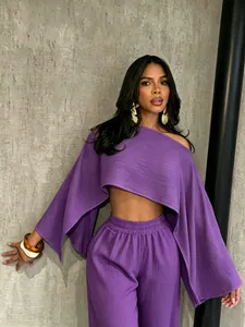 Foto de moda de un conjunto de top corto morado de un solo hombro y pantalón ancho a juego.
