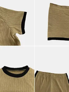 Close-up detail view showing pleated fabric texture and black contrast trim on women's set.