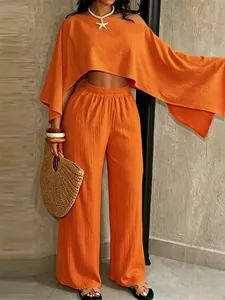 Conjunto de vacaciones naranja de dos piezas con top asimétrico y pantalones anchos